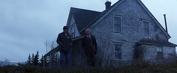 Movie still from “Dolores Claiborne” (1995), directed by Taylor Hackford – Two men standing in front of an old house; Wide shot, Low angle