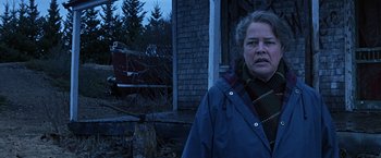 Movie still from “Dolores Claiborne” (1995), directed by Taylor Hackford – An older woman standing in front of an old house; Medium shot, Over the shoulder angle
