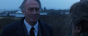 Movie still from “Dolores Claiborne” (1995), directed by Taylor Hackford – An older man wearing a suit and a tie; Close Up shot, Over the shoulder angle