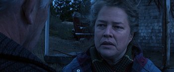 Movie still from “Dolores Claiborne” (1995), directed by Taylor Hackford – An older woman in a plaid shirt looking at the camera; Close Up shot, Low angle