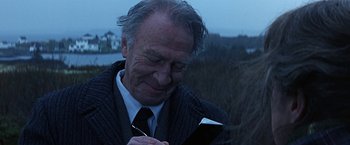 Movie still from “Dolores Claiborne” (1995), directed by Taylor Hackford – An older man holding a book in his hands; Close Up shot, Over the shoulder angle