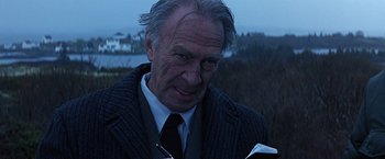 Movie still from “Dolores Claiborne” (1995), directed by Taylor Hackford – An older man in a suit and tie holding a book; Close Up shot, Low angle