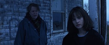 Movie still from “Dolores Claiborne” (1995), directed by Taylor Hackford – Two women standing in front of a brick building; Close Up shot, Over the shoulder angle