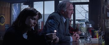 Movie still from “Dolores Claiborne” (1995), directed by Taylor Hackford – An older man sitting at a table next to a young woman; Medium shot, Over the shoulder angle