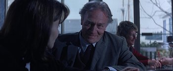 Movie still from “Dolores Claiborne” (1995), directed by Taylor Hackford – An older man wearing a suit and tie talking to a young woman; Close Up shot, Over the shoulder angle
