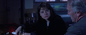 Movie still from “Dolores Claiborne” (1995), directed by Taylor Hackford – A woman sitting at a table in a dark room; Close Up shot, Over the shoulder angle