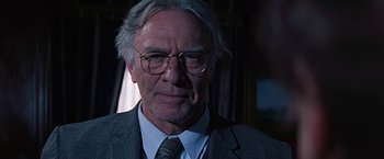 Movie still from “Dolores Claiborne” (1995), directed by Taylor Hackford – An older man wearing glasses and a suit; Close Up shot, Over the shoulder angle