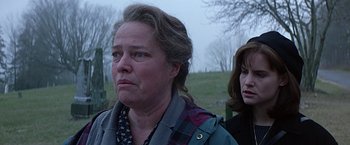 Movie still from “Dolores Claiborne” (1995), directed by Taylor Hackford – Two women standing next to each other on a field; Close Up shot, Over the shoulder angle