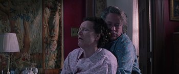 Movie still from “Dolores Claiborne” (1995), directed by Taylor Hackford – Two women in a room one is sitting and the other is standing; Medium shot, Low angle
