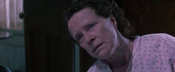 Movie still from “Dolores Claiborne” (1995), directed by Taylor Hackford – An older woman with blue eyes looking at the camera; Close Up shot, Low angle