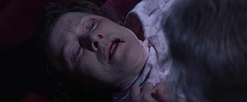 Movie still from “Dolores Claiborne” (1995), directed by Taylor Hackford – An older woman laying on a bed with blood all over her face; Close Up shot, High angle