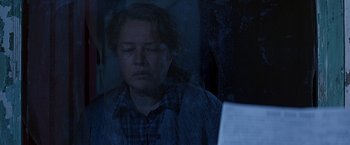 Movie still from “Dolores Claiborne” (1995), directed by Taylor Hackford – A woman sitting in front of a laptop computer in front of a window; Close Up shot, Over the shoulder angle