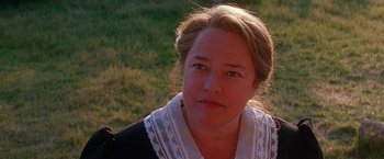 Movie still from “Dolores Claiborne” (1995), directed by Taylor Hackford – A woman with a white scarf sitting in the grass; Close Up shot, Over the shoulder angle