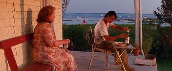 Movie still from “Dolores Claiborne” (1995), directed by Taylor Hackford – A man and a woman sitting at a table outside; Wide shot, Over the shoulder angle