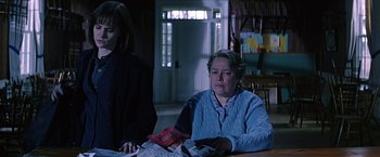 Movie still from “Dolores Claiborne” (1995), directed by Taylor Hackford – A woman sitting at a table in front of another woman; Medium shot, Low angle
