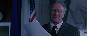 Movie still from “Dolores Claiborne” (1995), directed by Taylor Hackford – An older man in a suit and tie holding papers; Close Up shot, Low angle