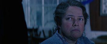Movie still from “Dolores Claiborne” (1995), directed by Taylor Hackford – An older woman looking at the camera in a dark room; Close Up shot, Low angle