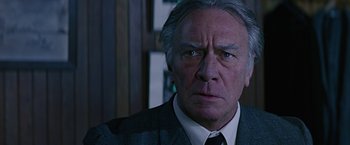 Movie still from “Dolores Claiborne” (1995), directed by Taylor Hackford – An older man in a suit and tie looking at the camera; Close Up shot, Low angle