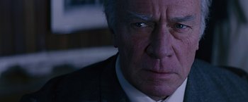 Movie still from “Dolores Claiborne” (1995), directed by Taylor Hackford – An older man in a suit stares into the camera; Extreme Close Up shot, Low angle