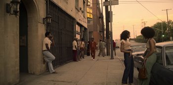 Movie still from “Dolemite Is My Name” (2019), directed by Craig Brewer – A group of people standing on a sidewalk near a building; Wide shot, High angle