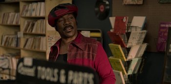 Movie still from “Dolemite Is My Name” (2019), directed by Craig Brewer – A man wearing a red jacket and a red hat; Medium shot, Over the shoulder angle