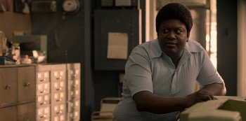 Movie still from “Dolemite Is My Name” (2019), directed by Craig Brewer – A man in a white shirt is sitting in a room; Close Up shot, Over the shoulder angle