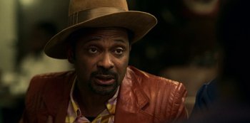 Movie still from “Dolemite Is My Name” (2019), directed by Craig Brewer – A person wearing a hat and a leather jacket; Close Up shot, Over the shoulder angle