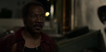 Movie still from “Dolemite Is My Name” (2019), directed by Craig Brewer – A man with a beard and a red shirt is looking at the camera; Close Up shot, High angle