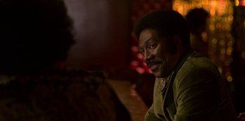 Movie still from “Dolemite Is My Name” (2019), directed by Craig Brewer – A man sitting in front of a wall; Close Up shot, Over the shoulder angle