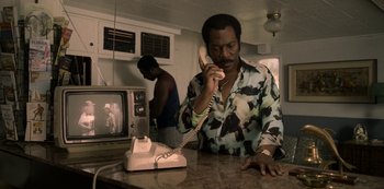 Movie still from “Dolemite Is My Name” (2019), directed by Craig Brewer – A man on the phone with another man in the background; Medium shot, Low angle
