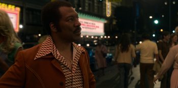 Movie still from “Dolemite Is My Name” (2019), directed by Craig Brewer – A man standing on the sidewalk at night; Medium shot, Over the shoulder angle