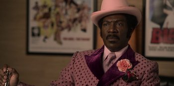 Movie still from “Dolemite Is My Name” (2019), directed by Craig Brewer – A man wearing a pink suit and pink hat; Close Up shot, Low angle