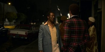 Movie still from “Dolemite Is My Name” (2019), directed by Craig Brewer – A man in a blue jacket and a man in a plaid jacket standing next to each other on the street; Medium shot, Over the shoulder angle