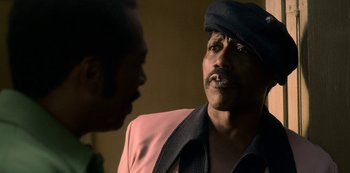 Movie still from “Dolemite Is My Name” (2019), directed by Craig Brewer – A man wearing a hat and a pink jacket; Close Up shot, Over the shoulder angle