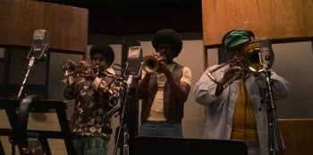 Movie still from “Dolemite Is My Name” (2019), directed by Craig Brewer – A group of people playing musical instruments in a room; Medium shot, Low angle