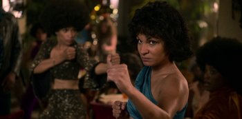 Movie still from “Dolemite Is My Name” (2019), directed by Craig Brewer – A woman in a blue top is holding her hands out to the camera; Medium shot, Over the shoulder angle