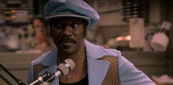 Movie still from “Dolemite Is My Name” (2019), directed by Craig Brewer – A person with a microphone; Close Up shot, Low angle