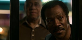 Movie still from “Dolemite Is My Name” (2019), directed by Craig Brewer – Two men standing next to each other in front of a wall; Close Up shot, Over the shoulder angle