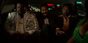 Movie still from “Dolemite Is My Name” (2019), directed by Craig Brewer – A group of men sitting in the back of a car; Medium shot, High angle
