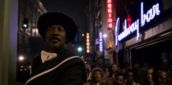 Movie still from “Dolemite Is My Name” (2019), directed by Craig Brewer – A man wearing a cowboy hat standing in front of a crowd of onlookers at night; Close Up shot, Low angle