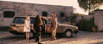 Movie still from “Don't Look Back” (2009), directed by Marina de Van – A woman standing next to a parked car; Wide shot, Over the shoulder angle