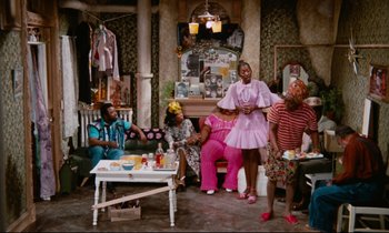 Movie still from “Don't Play Us Cheap” (1972), directed by Melvin Van Peebles – A group of people sitting around a living room; Wide shot, High angle