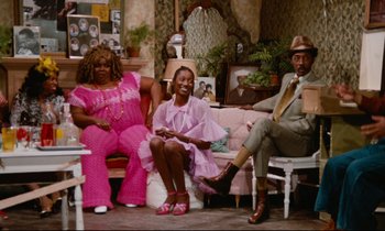 Movie still from “Don't Play Us Cheap” (1972), directed by Melvin Van Peebles – A group of people sitting in a living room together; Wide shot, High angle