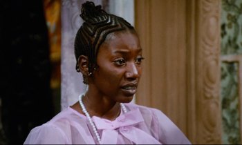 Movie still from “Don't Play Us Cheap” (1972), directed by Melvin Van Peebles – A person wearing a pink shirt; Close Up shot, High angle