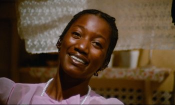 Movie still from “Don't Play Us Cheap” (1972), directed by Melvin Van Peebles – A person wearing a pink shirt; Close Up shot, Low angle