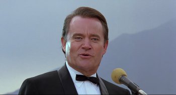 Movie still from “Double Impact” (1991), directed by Sheldon Lettich – A person wearing a suit and tie; Close Up shot, Low angle