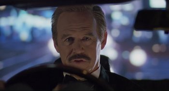 Movie still from “Double Impact” (1991), directed by Sheldon Lettich – A man with a mustache in a car; Close Up shot, Over the shoulder angle