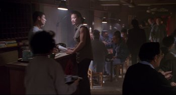 Movie still from “Double Impact” (1991), directed by Sheldon Lettich – A group of people sitting at a table in a restaurant; Medium shot, High angle