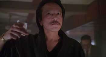 Movie still from “Double Impact” (1991), directed by Sheldon Lettich – A person wearing a black shirt; Close Up shot, Low angle