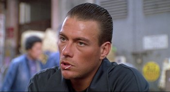 Movie still from “Double Impact” (1991), directed by Sheldon Lettich – A person smoking a cigarette; Close Up shot, Low angle
